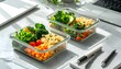 © EBG Stock Studio - Meal prep saludable en recipientes de vidrio con platos equilibrados sobre mesa de trabajo luminosa