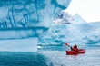 © Song_about_summer - kayak adventure expedition in Antarctica, man paddling on red kayak between icebergs