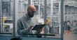 © Framestock - Technical Specialist, Using Table Monitor Status and Performance of Automated Factory Machinery in Clean, Modern Industrial Plant. Concept of Mobile Diagnostics and on Site Process Optimization.