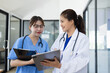 © SOMKID - Two asian female doctor with clipboard in modern clinic, Doctor woman and medical coat working in hospital.