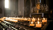 © rahatpix - Rows of lit candles in a dimly lit church interior