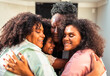 © Nexa - Four happy multi-generational Black women embracing each other with warmth and joy, celebrating family bonds.