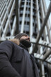© Antonio Recena - Attractive Forty Year Old Spanish Bearded Man Wearing Winter Hat and Coat Walking Through a Spanish City with a Large Building Behind
