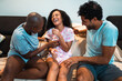 © Nexa - Happy diverse group of friends laughing and playing together on a couch at home, enjoying a fun and joyful moment in casual pajamas.