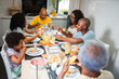 © Nexa - Happy multi-generational Black family enjoying a healthy breakfast together at home in the kitchen.