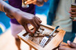 © Nexa - Close-up of hands taking grilled meat from a wooden board at an outdoor party with friends.