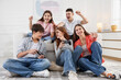 © New Africa - Happy teenagers playing video game together at home