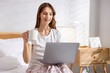 © New Africa - Woman with cup of coffee working on laptop at home