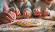 © AndiAzis - Children baking cookies with colorful sprinkles on a wooden table, showing hands dusted with flour and decorated sweet treats