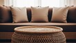 © ndandut - A wicker table in focus, with a brown sofa and pillows blurred in the background