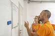© jovannig - Two electrical company employees discussing upcoming maintenance tasks while reviewing data on a computer