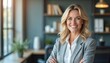 © Vadym - Confident woman smiles in office. Mature businesswoman stands with arms crossed, looking pro. Leader poses in modern workspace, happy, friendly, successful.