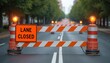 © Vadym - Orange traffic cones and striped barriers block urban street lane. Flashing yellow lights warn drivers of road work ahead. Construction site requires detour. Public safety measures are in place.