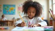 © Pete - Young black girl attentively draws with pencil on paper. She sits at wooden table in classroom, engaged in creative art activity. Child learns, develops imagination in preschool.
