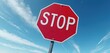 © Viktor - Red octagonal stop sign against bright blue sky with clouds. Common road sign demands drivers halt before proceeding. Warns of potential hazards, ensures traffic order. Reflective surface catches