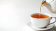© MinaNasrin - Hot tea being poured from white teapot into cup and saucer