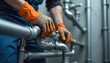 © Viktor - Plumber installs new pipe fittings for bathroom heating system. Worker wears orange gloves, blue uniform, fixes metal plumbing in house interior. Pro maintenance service.