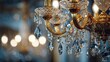 © Laura - Close-up of a gold chandelier, showcasing intricate crystal droplets, soft lighting, and blurred backdrop