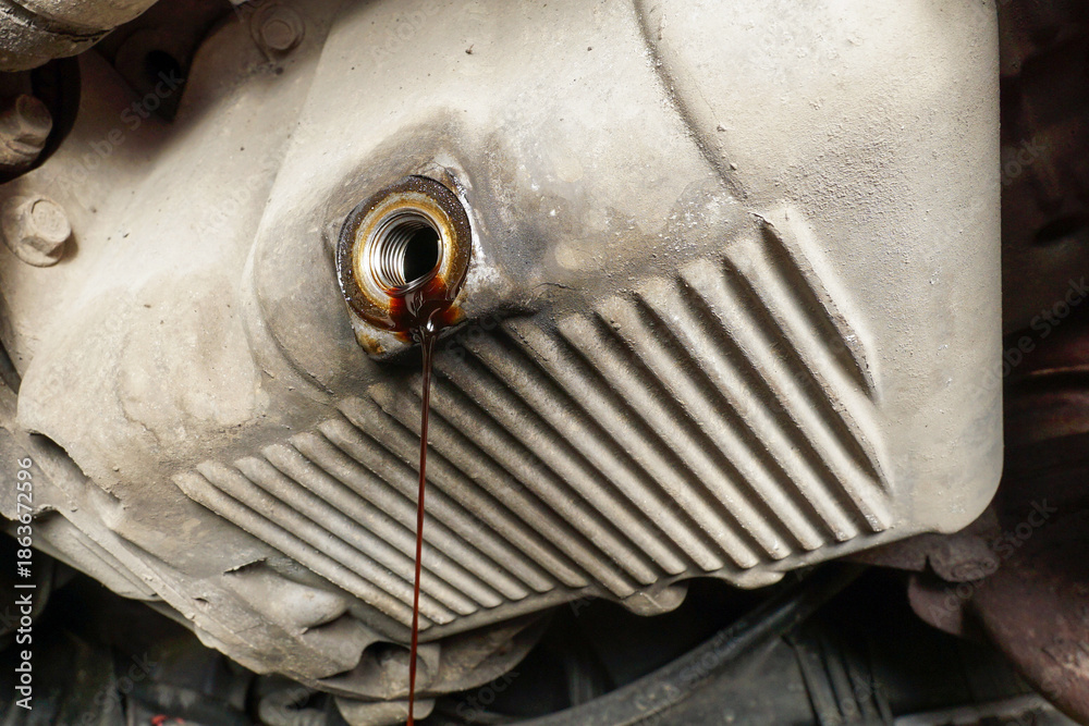 The process of draining used oil from the engine in a car service ...