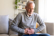 © Daniel - Senior man suffering from abdominal pain while sitting on sofa at home