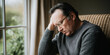 © Bonsales - Senior man in glasses sitting in an armchair by a window, experiencing sadness, depression, and stress