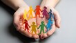 © youns - Manos de enfermera abrazando cadenas de papel de diversas figuras humanas, que simbolizan la neurodiversidad, la concienciación sobre el autismo, el apoyo comunitario y un enfoque de atención sanitari