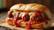 © Maryna - Meatball sub sandwich stuffed with cheesy meatballs and marinara sauce on a toasted bun, offering a rich, savory, and hearty comfort food meal.
