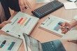 © MrAshi - Two accountants use calculators to perform company financial calculations, handle accounting on laptop computers at their desks, manage budgets, and handle financial tasks.