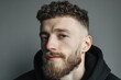 © Michael - Young man with a stylish beard, curly hair, and a fade haircut looking at the camera