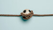 © Jess rodriguez - Soccer ball tied with a hemp rope knot on a light blue background, concept of restriction and sporting pressure