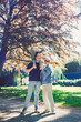 © DSMT - Family enjoys a sunny day outdoors with a child on a man's shoulders near trees in a park setting