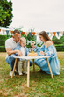 © DSMT - Family celebrates child's birthday with cake and decorations in backyard garden during sunny afternoon
