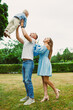 © DSMT - Family plays together in park with child in early afternoon light during a warm day in summer
