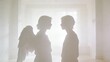 © Bay - Soft silhouettes of two figures in bright room, one figure suggests angelic presence with implied wings, creating a moment of encounter