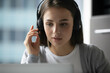 © fizkes - Client support connection. Close up portrait confident young female online service agent helpdesk manager in digital earphones with microphone consult customer by videocall assist on laptop video chat