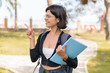 © luismolinero - Young Bulgarian student woman at outdoors pointing to the side to present a product