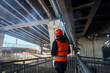 © Michael - Back view of worker inspecting urban bridge base