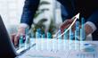 © Father_Studio - Businessman analyzing company metrics on tablet and laptop, reviewing digital performance dashboards, guiding strategic planning, market analysis, and data-driven business decisions.