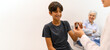 © Moon Safari - Cropped hand of female doctor giving prescribed medicines to smiling boy against white background in hospital