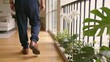 © CreativeLoom - elderly Person walking indoors on wooden floor beside plants and railing Retirement Living concept