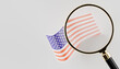© Layerform - flag of united states with magnifying glass over the top, plain background