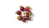 Cluster of Garcinia mangostana fruits arranged on a plain white surface, highlighting their fresh appearance and size differences