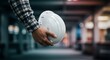 © VectorStar - man holding white safety helmet in hand in construction site
