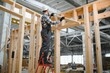 © Serhii - A carpenter works on the construction of modular houses