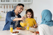 © Prostock-studio - Happy Middle Eastern Family With Little Daughter Enjoying Tasty Breakfast In Kitchen Together, Cheerful Arabic Parents And Their Child Eating Healthy Food And Drinking Orange Juice At Home, Closeup