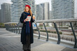 © Jelena - Woman holding tablet and coffee cup in city