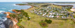 © Austockphoto - Aerial panorama of a small coastal town and golf course perched above a rugged coastline