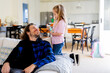 © Austockphoto - Young girl holding a spray bottle beside dad sitting on the couch