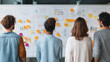 © marini - Team brainstorming with whiteboard full of charts and sticky notes, clean modern office