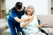 © Nuttapong punna - Asian nurse caring for elderly woman in wheelchair at home. Senior care, home healthcare, nursing support, compassion and professional caregiver concept